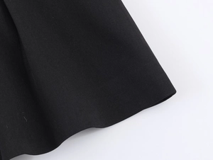 Close-up of the black twill fabric texture and peplum hem detail on the blazer