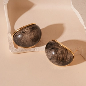 Detail of vintage resin hoop earrings with golden edges and smoky black swirl texture
