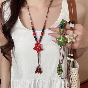 Detailed macro of ceramic starfish pendants on wax cord with beaded tassels