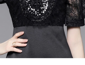 Detail of black lace dress featuring heavy beadwork and sequin embroidery on waist and sleeve