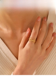 Close-up of three-layer 18K gold plated stainless steel textured rings on finger
