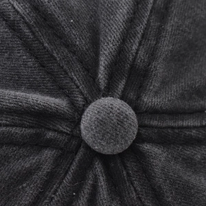 Macro shot of the top button and stitched twill fabric texture of the black cotton baseball cap