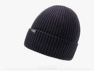 Dettaglio del berretto in maglia a coste blu navy con etichetta tessuta del marchio FUMY