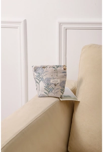 Detail of floral makeup bag featuring golden flower zipper and blue hydrangea pattern