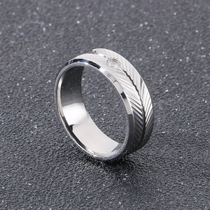 Detail shot of men's stainless steel ring with feather textures and centered diamond inlay