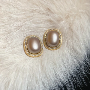 Detail of vintage oval stud earrings with champagne purple stone and zircon inlay