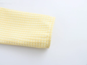 Close-up of yellow tweed fabric texture with detailed woven check pattern and soft lighting