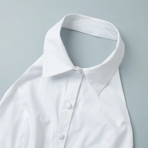 Détail d'un col pointu blanc avec trois boutons ronds et des coutures fines