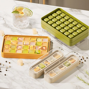 Macro view of green and yellow silicone ice cube trays with lids on marble surface