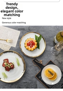 Detail of Nordic white ceramic dinner plate with luxury gold rim on stone surface