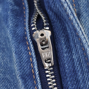 Détail en gros plan du tissu denim bleu et de la fermeture éclair en métal argenté
