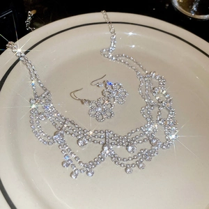 Close-up of sparkling floral diamond necklace and earring set with starburst light effect