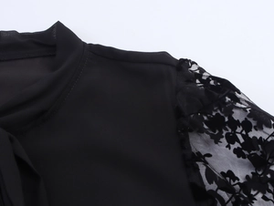 Dettaglio della spalla in pizzo nero elegante e manica con fiori floccati in rilievo