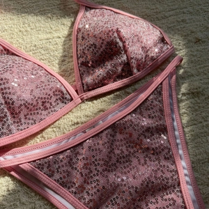 Detailed view of pink sequin bikini top with adjustable straps on a soft texture