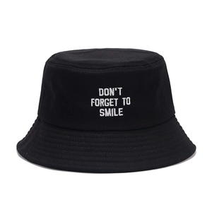 Classic black canvas bucket hat featuring white embroidered text don't forget to smile