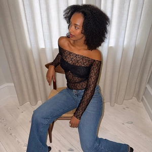 Détail d'un haut slim en dentelle noire à épaules dénudées avec des manches longues voilées