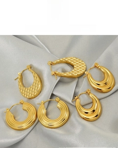 Détail de boucles d'oreilles géométriques plaquées or 18 carats sur fond de soie