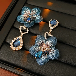Détail des boucles d'oreilles et broche vintage en tissu bleu avec cristaux
