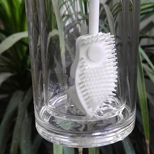 Silicone bottle brush with long handle in a clear glass for household cup cleaning
