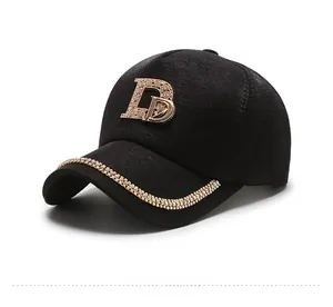 Detail of the black baseball cap featuring a sparkling rhinestone D logo and crystal trim