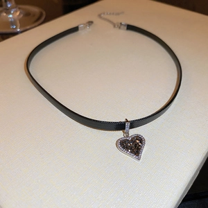 Close-up of black leather heart choker with dark crystals and adjustable silver chain