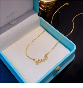 Makroaufnahme von Gold-Anhänger LOVE mit Kronen-Design und Diamanten in Schmuckbox