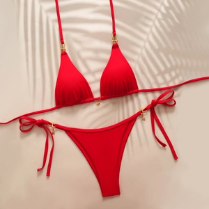 Sexy red halter bikini set with gold star charms and side-tie bottoms on beach background