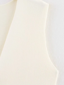 Nahaufnahme der cremeweißen Strickweste zeigt die detaillierte Textur des Gewebes