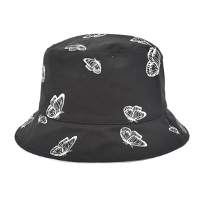 Détail d'un bob réversible noir avec imprimé papillon blanc intégral en toile de coton