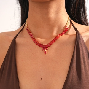 Gros plan du collier avec pendentif en épi de blé en zircon rouge et chaîne dorée