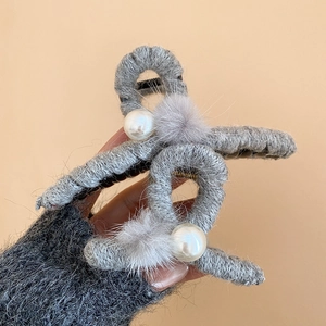 Detail einer grauen Strick-Haarklammer mit weißen Kunstperlen und weichen Pompon-Akzenten