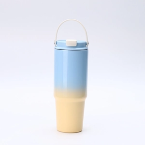 Detail of 30oz insulated tumbler with blue and yellow gradient finish and white handle