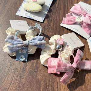 Detailed close-up of plaid fabric hair accessories with wooden buttons and lace trims