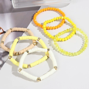 Detail of 6-piece bohemian stackable bracelets with clay heishi beads and gold accents