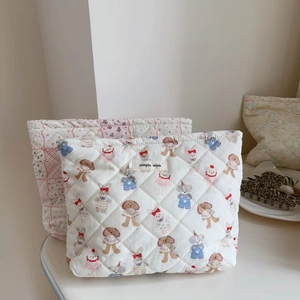 Detailed close-up of quilted floral and animal pattern cotton cosmetic storage bags