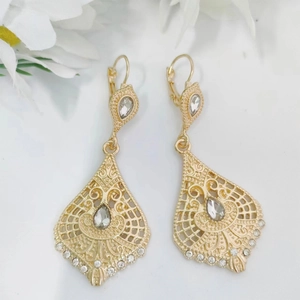 Vintage gold hollow teardrop earrings with crystals and bohemian pattern on white background
