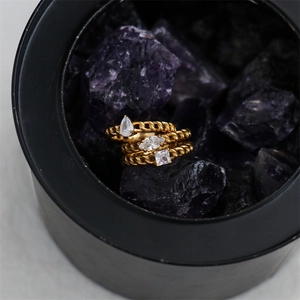Detail of 18K gold plated chain rings with teardrop and square zircon in a jewelry box