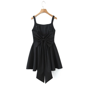 Detail of a black backless mini dress featuring a large decorative bow on the back