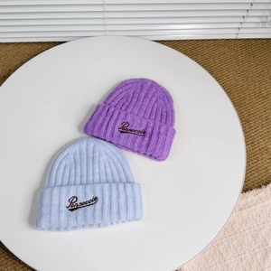 Close-up of wool knit beanies with Persecole embroidery in purple and light blue