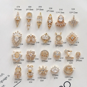 Dettaglio macro di ciondoli geometrici in rame per nail art con zirconi micro-incastonati