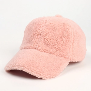 Macro detail of plush pink lamb wool texture on a winter baseball cap with curved brim