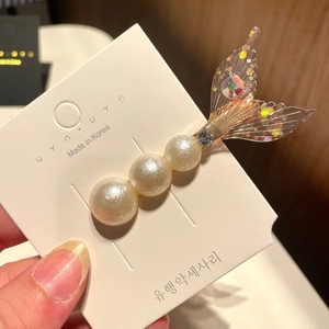 Detail of mermaid pearl hair clip with glitter fish tail and sparkling rhinestones