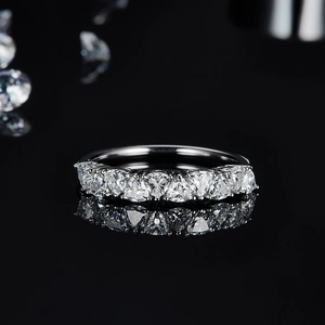 Macro shot of silver ring featuring triangle cut moissanite stones with reflection