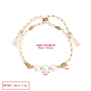 Detailed view of woven green rope bracelet with white pearls and gold beads size specs