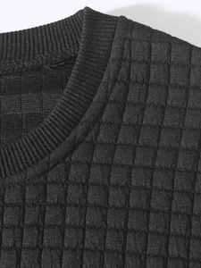 Close-up of the waffle texture and ribbed crew neck on this black slim fit sweatshirt