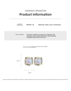 Détail de boucles d'oreilles carrées dorées avec résine violette, cristaux et argent