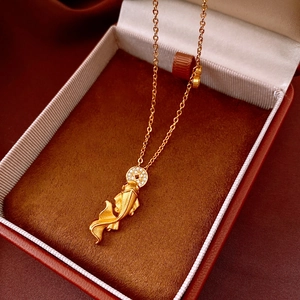 Detail of a golden koi fish pendant with white zircon inlays on a premium velvet jewelry box