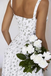 Detail of floral spaghetti strap dress showing fabric texture and elegant open back design