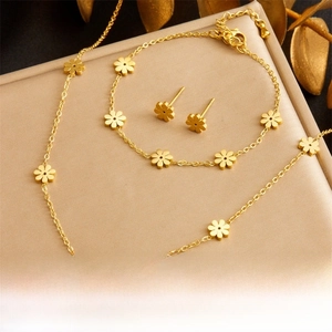 Detail of gold flower jewelry set including necklace, bracelet and stud earrings