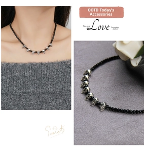 Macro view of gothic punk black beaded necklace with silver skull charms and faceted beads